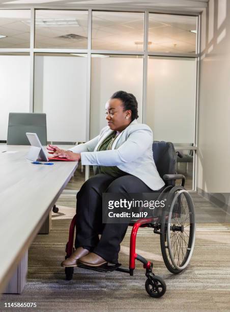 african-american businesswoman in wheelchair uses tablet - of deformed people stock pictures, royalty-free photos & images