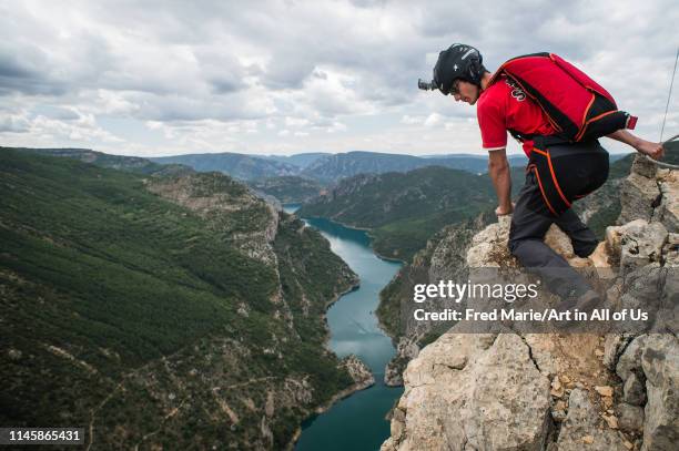 Man with a parachute doing base jump from a cliff in spain, Huesca, Puente de montañana, Spain on May 23, 2014 in Puente De Montañana, Spain.