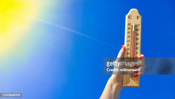 thermometer against a bright blue sky - heatwave stockfoto's en -beelden