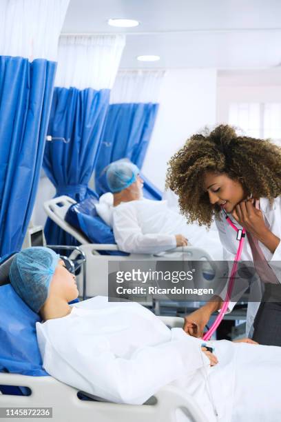 非裔美國醫生, 在進入手術室之前對一名年輕病人進行勘探。 - adulto joven 個照片及圖片檔