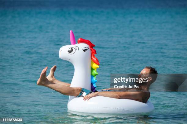 homme sur la licorne flottante - float photos et images de collection