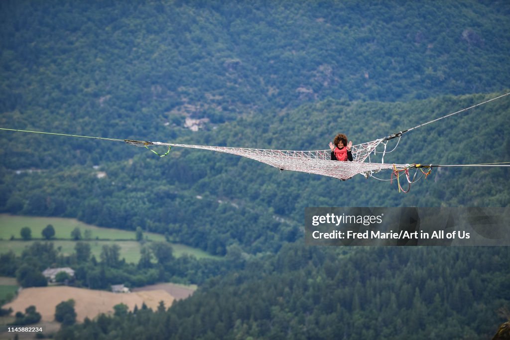 Sophie ducasse in a space net on the top of a cliff, Occitanie, Florac, France...