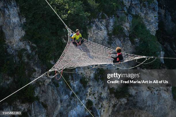 Sophie ducasse and a man in a space net on the top of a cliff, Occitanie, Florac, France on July 3, 2017 in Florac, France.