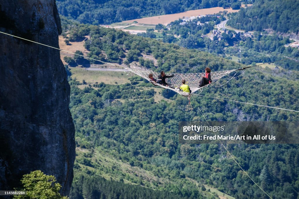 Joeystarr and sophie ducasse in a space net on the top of a cliff, Occitanie, Florac, France...