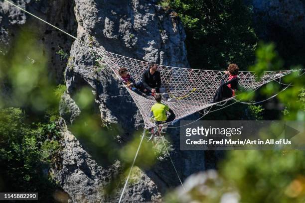 Joeystarr and sophie ducasse in a space net on the top of a cliff, Occitanie, Florac, France on July 3, 2017 in Florac, France.