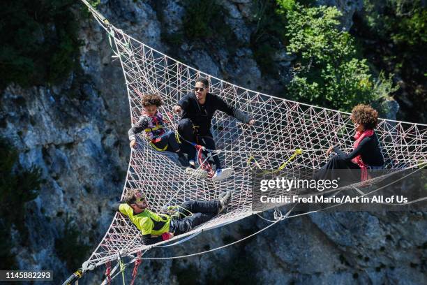 Joeystarr and sophie ducasse in a space net on the top of a cliff, Occitanie, Florac, France on July 3, 2017 in Florac, France.