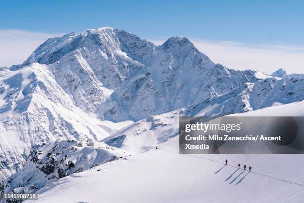 ski mountaineers advance towards mountain summit - monte elbrús fotografías e imágenes de stock