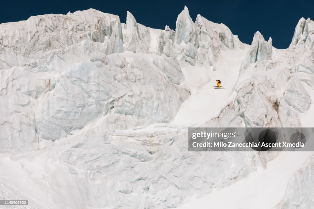 Ski mountaineer descends mountain through serac field