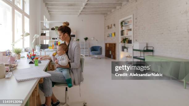 mamá moderna trabajando con el bebé en una vuelta - working mother fotografías e imágenes de stock