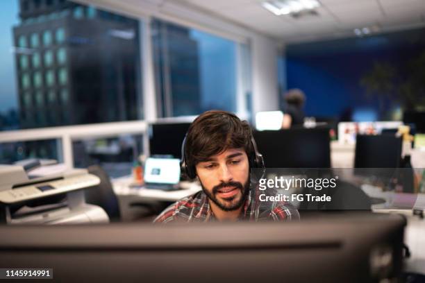 employee working with headset in office callcenter - mann headset stock-fotos und bilder