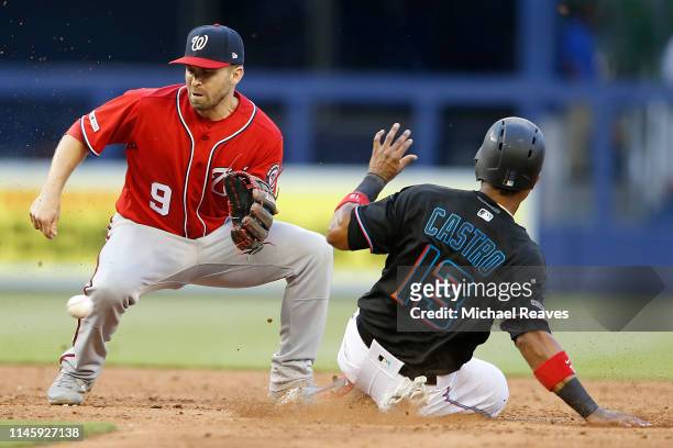 Starlin Castro of the Miami Marlins safely steals second past the tag of Brian Dozier of the Washington Nationals at Marlins Park on April 20, 2019...