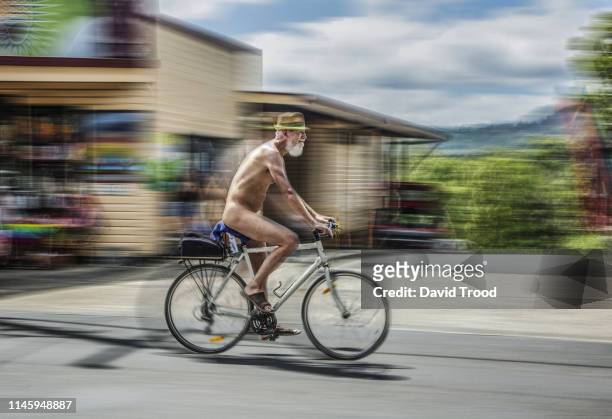 naked man on bicycle - birthday suit stock-fotos und bilder