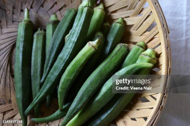 close-up of okra/ladies' fingers in a bamboo basket - okra stock pictures, royalty-free photos & images