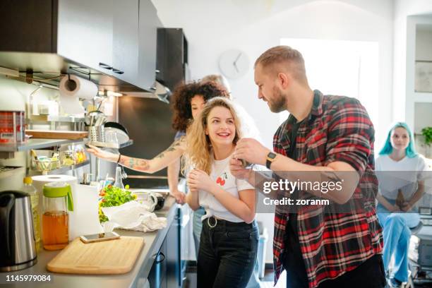 les jeunes colocataires gais avec des amis dans la cuisine - new age concept photos et images de collection