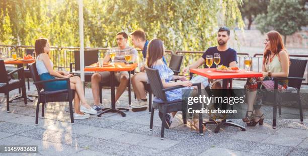 unga människor som kopplar av i uteplatsen avsnitt - restaurant patio bildbanksfoton och bilder