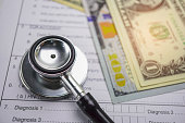 Health insurance accident claim form with stethoscope and US dollar banknotes, Medical concept.