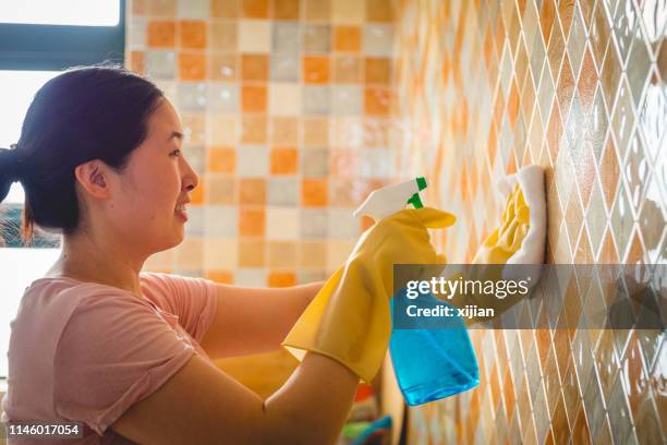 woman cleaning tiles at home - cleaning walls stock pictures, royalty-free photos & images