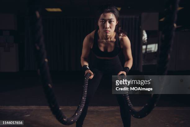 a young asian woman performs strength training in a gym - auckland train stockfoto's en -beelden