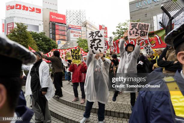 Demonstrators hold signs and chant slogans during a protest against Japan's Emperor system on April 30, 2019 in Tokyo, Japan. Japan's 85-year-old...