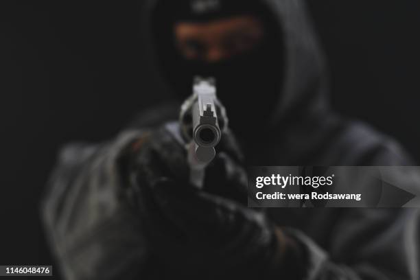 masked armed robbers pointing a handgun to robbery the money - montage stock pictures, royalty-free photos & images