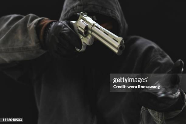 masked armed robbers pointing a handgun - armed robbery stock pictures, royalty-free photos & images