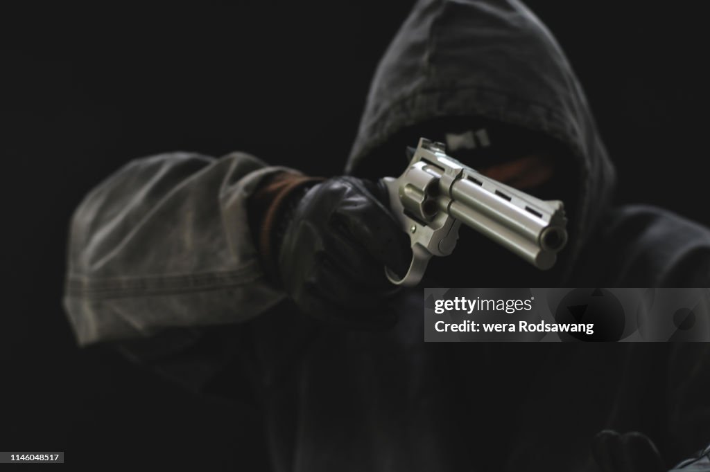 Masked Armed robbers pointing a handgun to robbery the money, Uses Gun in Armed Robbery, Gun Point , used for the illustration or montage of your design, Banner for advertise of product