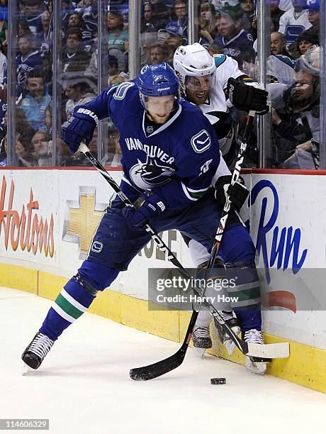 Alexander Edler of the Vancouver Canucks checks Joe Pavelski of the San Jose Sharks off the puck in the first period in Game Five of the Western...