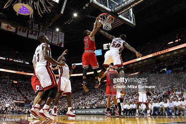 Derrick Rose of the Chicago Bulls dunks on Joel Anthony of the Miami Heat as LeBron James of the Heat looks on in the first half of Game Four of the...