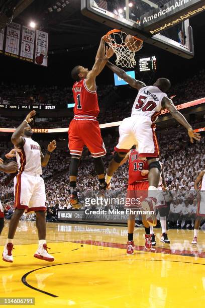 Derrick Rose of the Chicago Bulls dunks on Joel Anthony of the Miami Heat as LeBron James of the Heat looks on in the first half of Game Four of the...