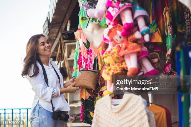tourist buying in the handicraft market - pop up stock pictures, royalty-free photos & images