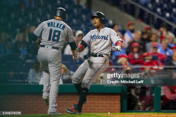 Starlin Castro of the Miami Marlins celebrates with Neil Walker after hitting a two run home run in the top of the tenth inning against the...