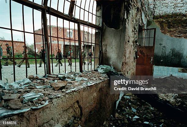 Soldiers in the Kosovo Liberation Army march past a destroyed house in a central Kosovo village Sunday Nov. 1, 1998. The KLA has held a unilateral...