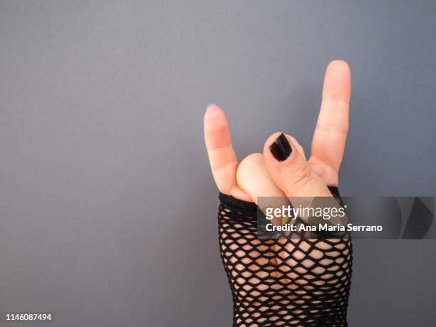 an unrecognizable woman gesturing with his hand - heavy metal horns stock pictures, royalty-free photos & images