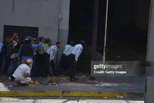 Pro-Juan Guaido military police officers confront Pro-Government armed civilians trying to protect themselves inside the Ministry of Housing at...