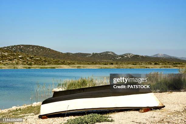 upside down boat in prosika port at lake vrana (vransko jezero) largest lake in croatia - capsizing stock pictures, royalty-free photos & images