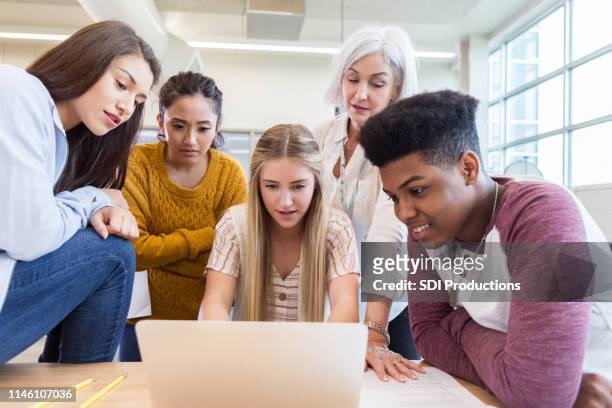 gruppe der gymnasiasten teilen sich laptop - school notebook stock-fotos und bilder