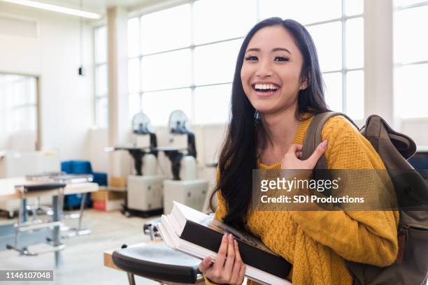 portrait of cheerful teen girl in classroom - first day of school concept stock pictures, royalty-free photos & images