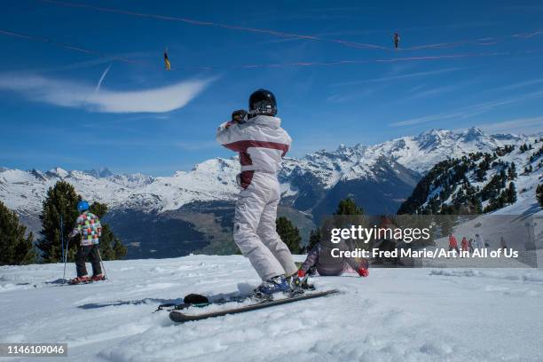 Skier taking pictures of people doing a highline in the french alps, Auvergne-rhone-alpes, Bourg-saint-maurice, France on April 7, 2017 in...