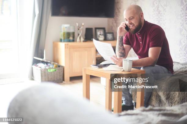 smiling homeowner on the phone to customer services - energy bill stock pictures, royalty-free photos & images