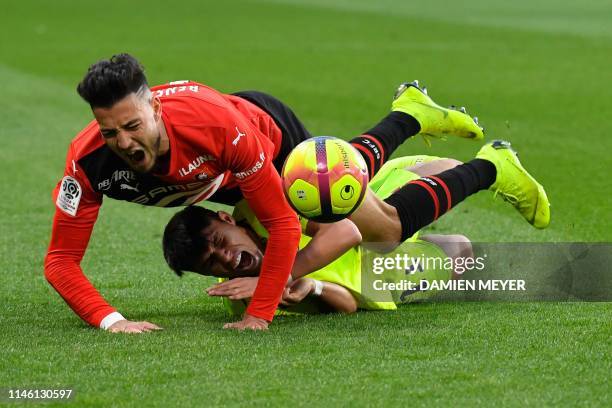 Rennes' Algerian defender Rami Bensebaini falls with Lille's Brazilian forward Luiz Araujo during the French L1 football match between Rennes and...