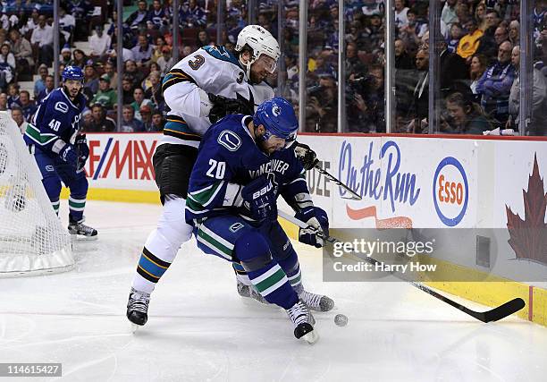 Douglas Murray of the San Jose Sharks and Christopher Higgins of the Vancouver Canucks vie for puck possession in the corner in the second period in...