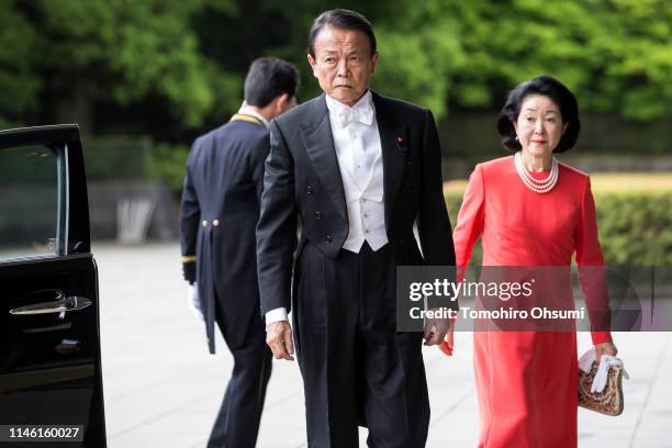 Japan's Deputy Prime Minister and Finance Minister Taro Aso and his wife Chikako arrive for Emperor Naruhito's ceremony for inheriting the Imperial...