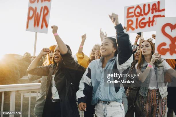 young women shouting while protesting for equal rights against sky - marcher - fotografias e filmes do acervo