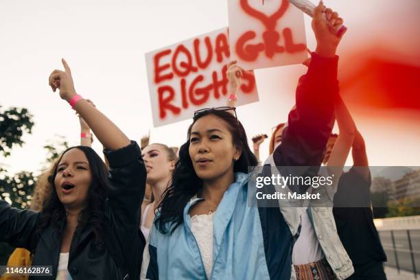 women with banners protesting together for equal rights against sky - aapi protest stock pictures, royalty-free photos & images