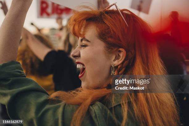 close-up of young woman shouting while protesting for rights - protest stock-fotos und bilder