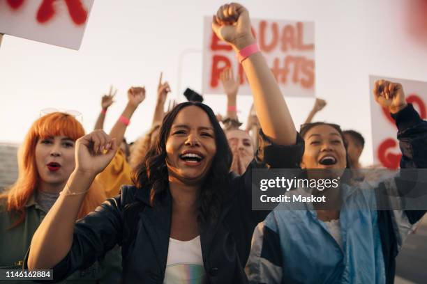 happy women shouting for equal rights while marching together - women protest stock-fotos und bilder