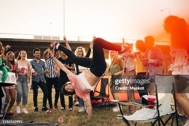 happy friends looking at man dancing in musical event against sky in summer - freestyle dance stock pictures, royalty-free photos & images