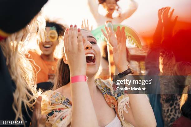 female fan screaming in crowd at music concert - chillar fotografías e imágenes de stock