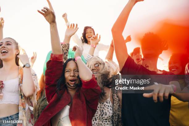 multi-ethnic cheerful fans enjoying in music concert during sunny day - crowd anticipation stock pictures, royalty-free photos & images