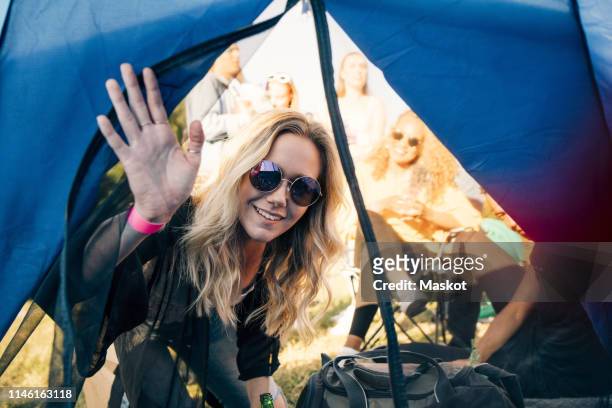 portrait of smiling woman with friends looking in tent at festival - entertainment tent stock pictures, royalty-free photos & images